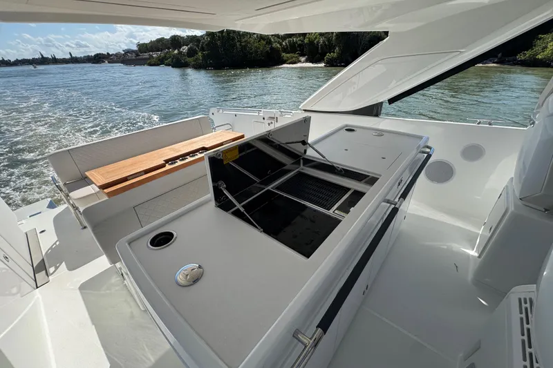 Slide: The Image of 2024 Jeanneau DB43 yacht deck with outdoor kitchen and scenic water view. - 21