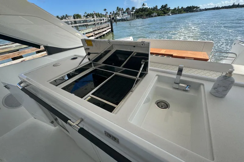 Slide: The Image of Outdoor kitchen on 2024 Jeanneau DB43 yacht with sink and grill, overlooking water. - 23