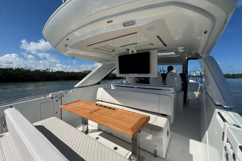 Slide: The Image of Luxurious 2024 Jeanneau DB43 yacht interior with seating, table, and TV, cruising on a sunny day. - 24