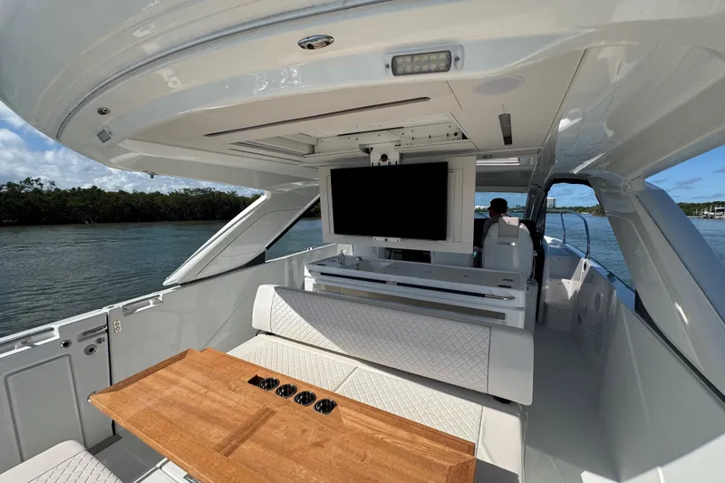 Slide: The Image of 2024 Jeanneau DB43 yacht interior with seating, table, and TV, cruising on a sunny day. - 25