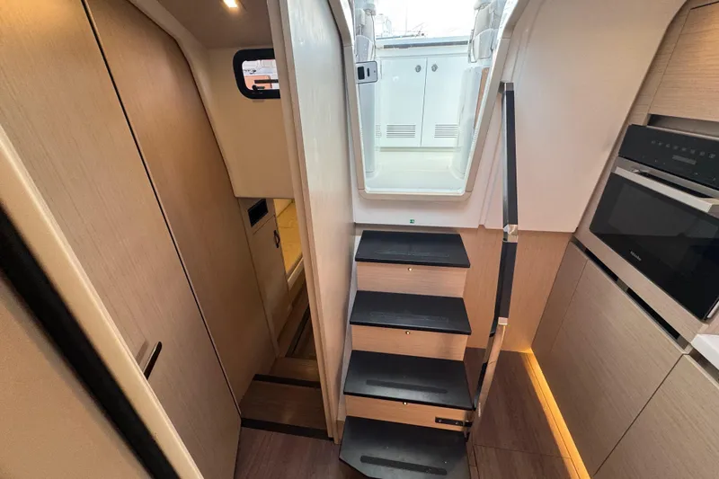Slide: The Image of Interior of 2024 Jeanneau DB43 yacht, featuring modern stairs and sleek kitchen area. - 34