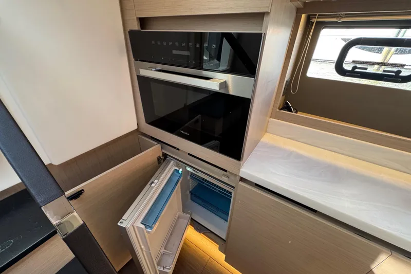 Slide: The Image of Modern kitchen area in 2024 Jeanneau DB43 yacht with oven and open fridge. - 36