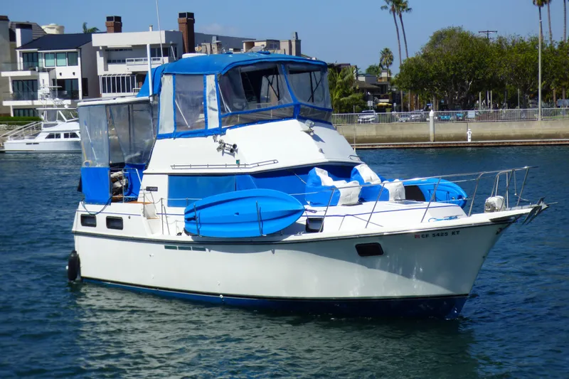 The Image of 1985 Carver 3607 Aft Cabin Motor Yacht with blue accents on the water. - 0
