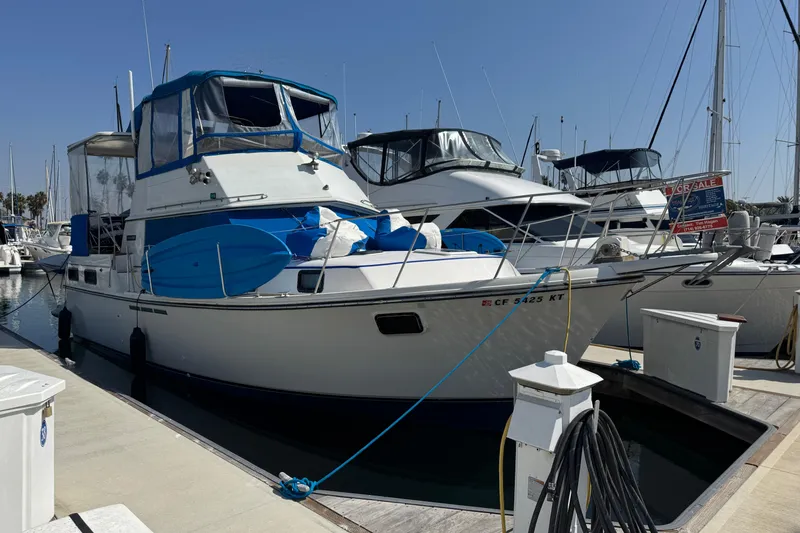 Slide: The Image of 1985 Carver 3607 Aft Cabin Motor Yacht docked at marina, for sale sign visible. - 10