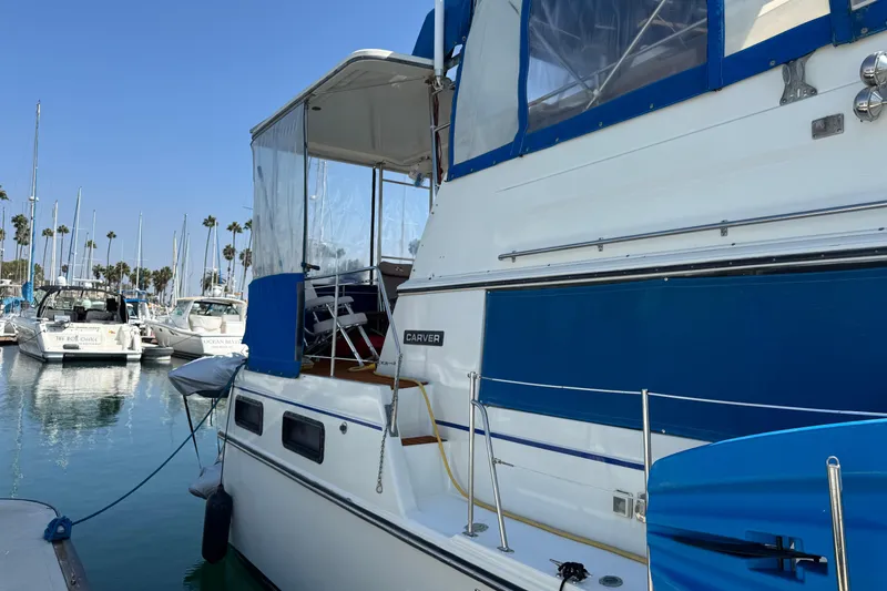 Slide: The Image of 1985 Carver 3607 Aft Cabin Motor Yacht docked in a marina, clear blue sky. - 11