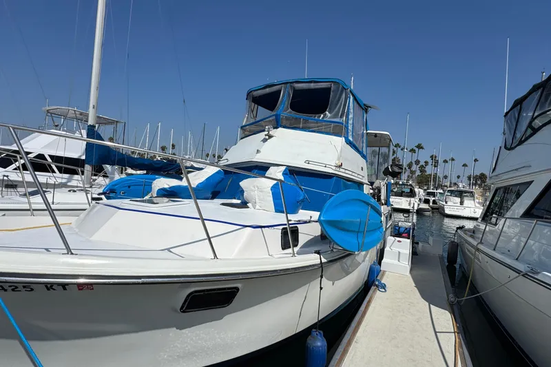 Slide: The Image of 1985 Carver 3607 Aft Cabin Motor Yacht docked at marina under clear blue sky. - 14