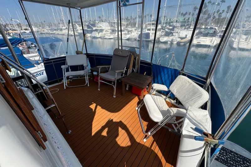 Slide: The Image of 1985 Carver 3607 Aft Cabin Motor Yacht deck with chairs and marina view. - 18