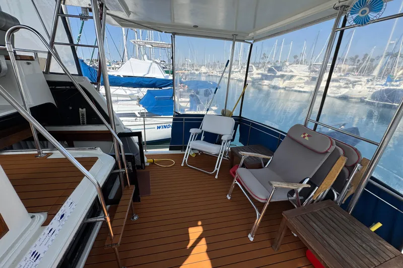 Slide: The Image of 1985 Carver 3607 Aft Cabin Motor Yacht interior with seating, docked at marina. - 19