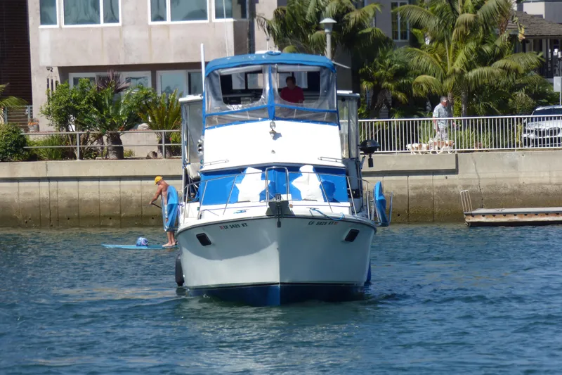 Slide: The Image of 1985 Carver 3607 Aft Cabin Motor Yacht on water near residential area. - 2