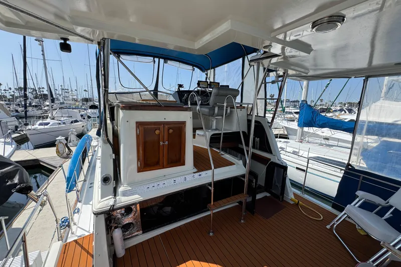 Slide: The Image of 1985 Carver 3607 Aft Cabin Motor Yacht interior with wooden deck and marina view. - 20
