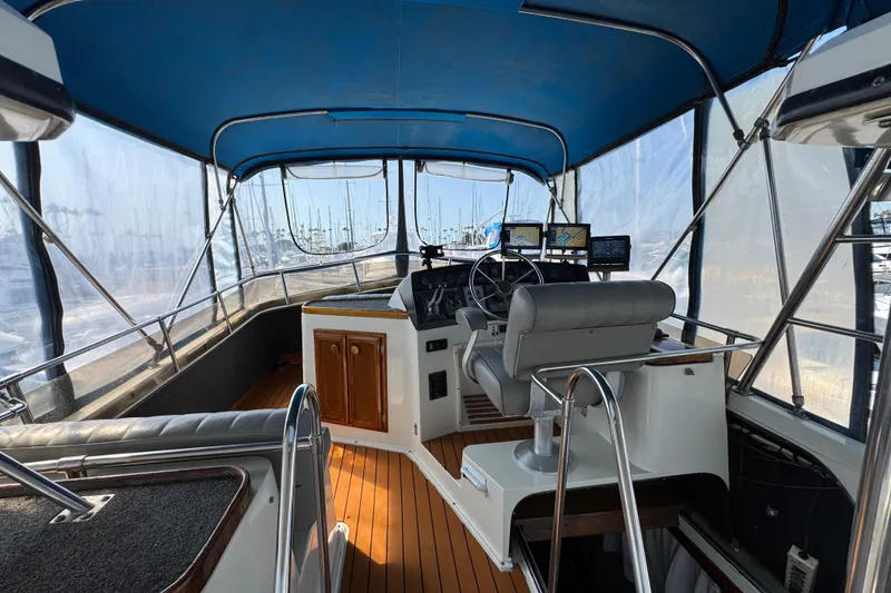 Slide: The Image of 1985 Carver 3607 Aft Cabin Motor Yacht helm with blue canopy and navigation equipment. - 21