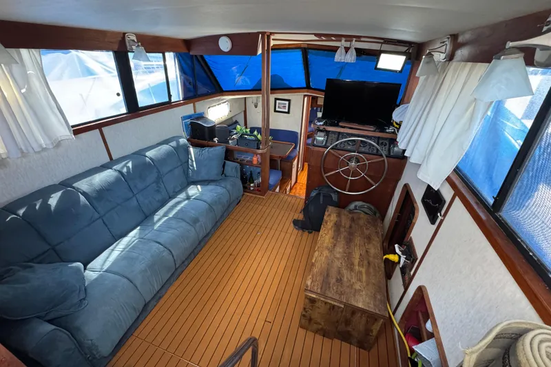 Slide: The Image of Interior of 1985 Carver 3607 Aft Cabin Motor Yacht with blue sofa and wooden accents. - 37