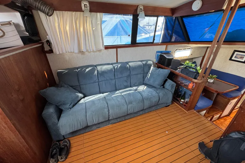 Slide: The Image of Interior of 1985 Carver 3607 Aft Cabin Motor Yacht with blue sofa and wooden flooring. - 39