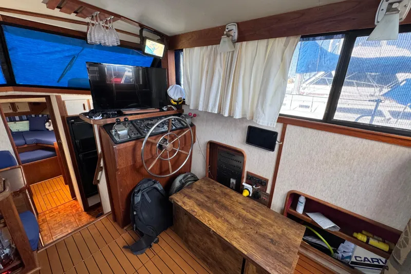 Slide: The Image of 1985 Carver 3607 Aft Cabin Motor Yacht interior with helm, TV, and seating area. - 40