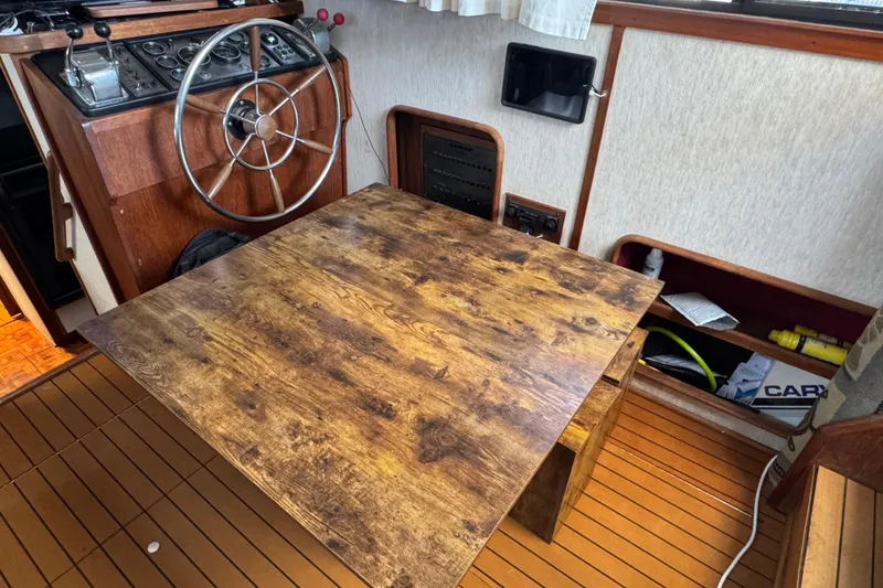 Slide: The Image of 1985 Carver 3607 Aft Cabin Motor Yacht interior with wooden table and steering wheel. - 42