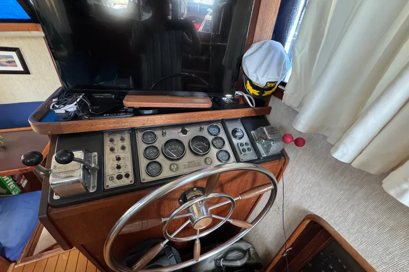 Slide: The Image of 1985 Carver 3607 Aft Cabin Motor Yacht helm with steering wheel and control panel. - 45