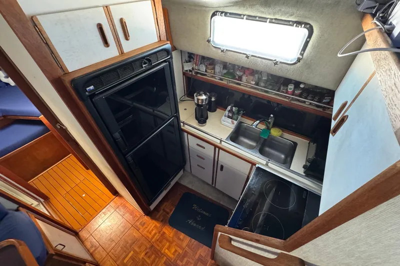 Slide: The Image of 1985 Carver 3607 Aft Cabin Motor Yacht kitchen with stove, sink, and refrigerator. - 50