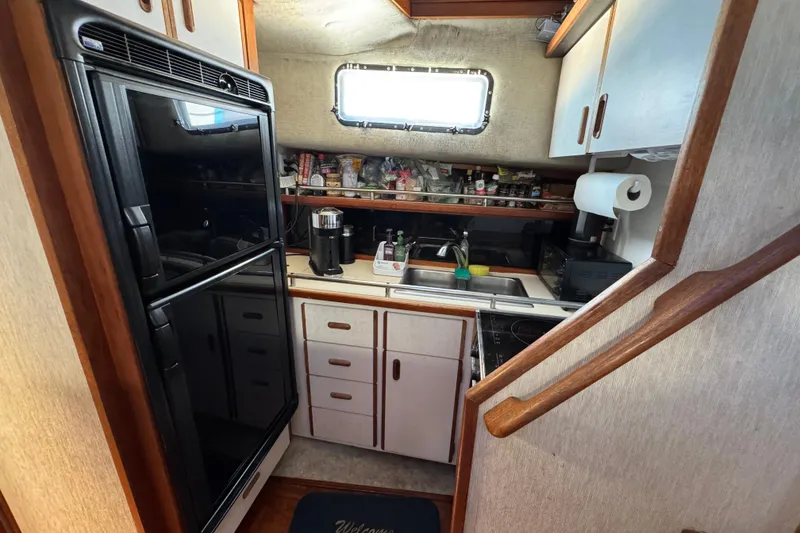 Slide: The Image of Compact kitchen in 1985 Carver 3607 Aft Cabin Motor Yacht with appliances and storage. - 53