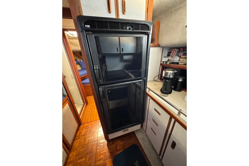 Slide: The Image of 1985 Carver 3607 Aft Cabin Motor Yacht interior kitchen with refrigerator and coffee maker. - 59