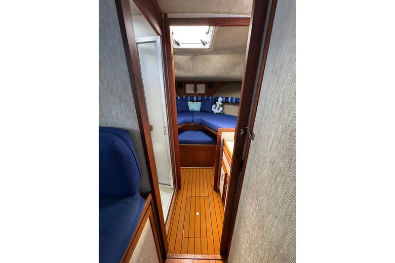 Slide: The Image of 1985 Carver 3607 Aft Cabin Motor Yacht interior with wood flooring and blue seating. - 60