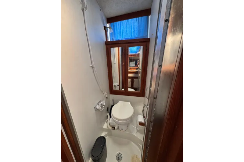 Slide: The Image of Bathroom interior of 1985 Carver 3607 Aft Cabin Motor Yacht, featuring toilet and mirror. - 63