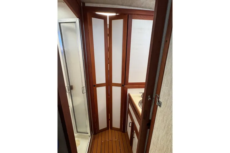 Slide: The Image of 1985 Carver 3607 Aft Cabin Motor Yacht bathroom with shower and wooden accents. - 66