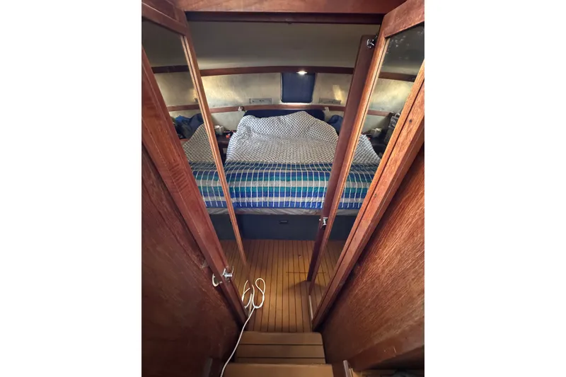 Slide: The Image of 1985 Carver 3607 Aft Cabin Motor Yacht interior with cozy bed and wooden finish. - 68