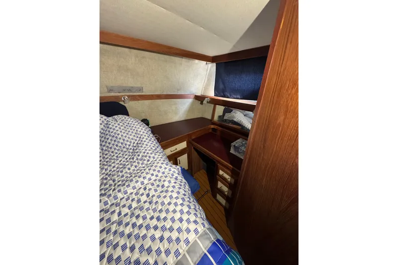 Slide: The Image of 1985 Carver 3607 Aft Cabin Motor Yacht interior with cozy bed and wooden cabinetry. - 73
