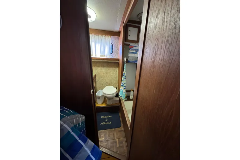 Slide: The Image of 1985 Carver 3607 Aft Cabin Motor Yacht bathroom with toilet and storage. - 74