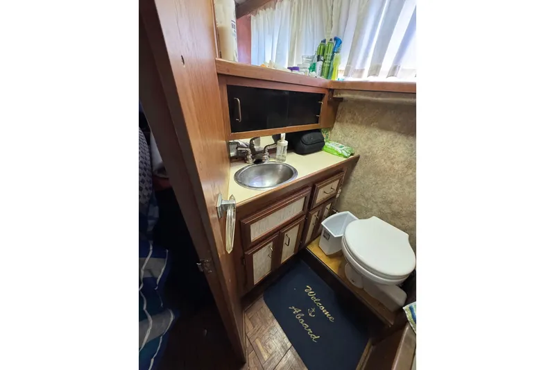Slide: The Image of 1985 Carver 3607 Aft Cabin Motor Yacht bathroom with sink and toilet. - 76