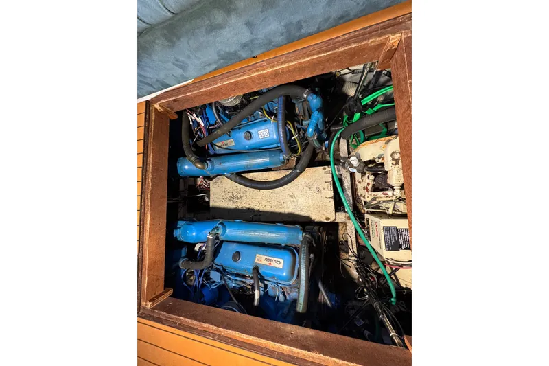 Slide: The Image of Engine compartment of 1985 Carver 3607 Aft Cabin Motor Yacht, featuring blue marine engines. - 79