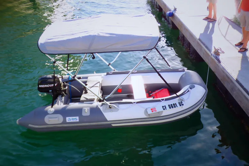 Slide: The Image of Inflatable boat with canopy docked beside a pier, featuring a Mercury outboard motor. - 8