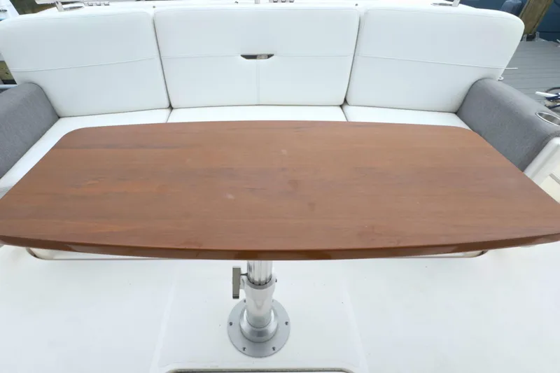 Slide: The Image of Wooden table on 2018 Tiara Yachts C44 Coupe, surrounded by white seating. - 17