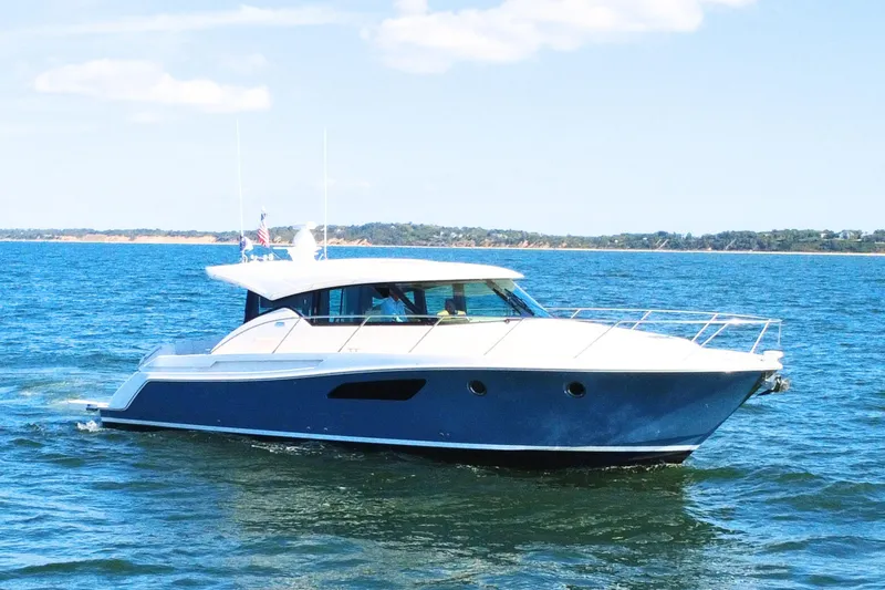 Slide: The Image of 2018 Tiara Yachts C44 Coupe cruising on open water under a clear sky. - 2