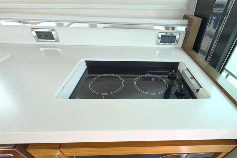 Slide: The Image of Modern kitchen area in 2018 Tiara Yachts C44 Coupe with electric stovetop. - 24