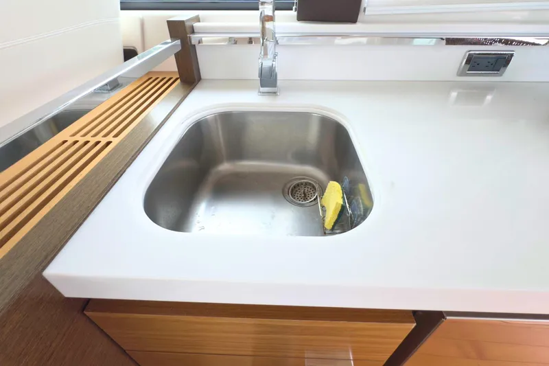 Slide: The Image of Modern kitchen sink in 2018 Tiara Yachts C44 Coupe, featuring sleek design and wooden accents. - 29