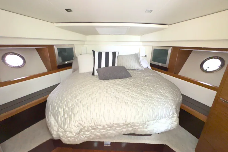 Slide: The Image of Luxurious bedroom interior of 2018 Tiara Yachts C44 Coupe with elegant bedding and porthole windows. - 47