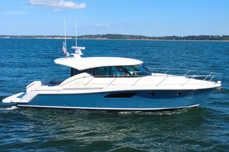 Slide: The Image of 2018 Tiara Yachts C44 Coupe cruising on open water under clear skies. - 5
