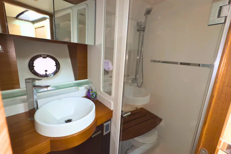 Slide: The Image of Luxurious bathroom in 2018 Tiara Yachts C44 Coupe with modern fixtures and porthole window. - 58