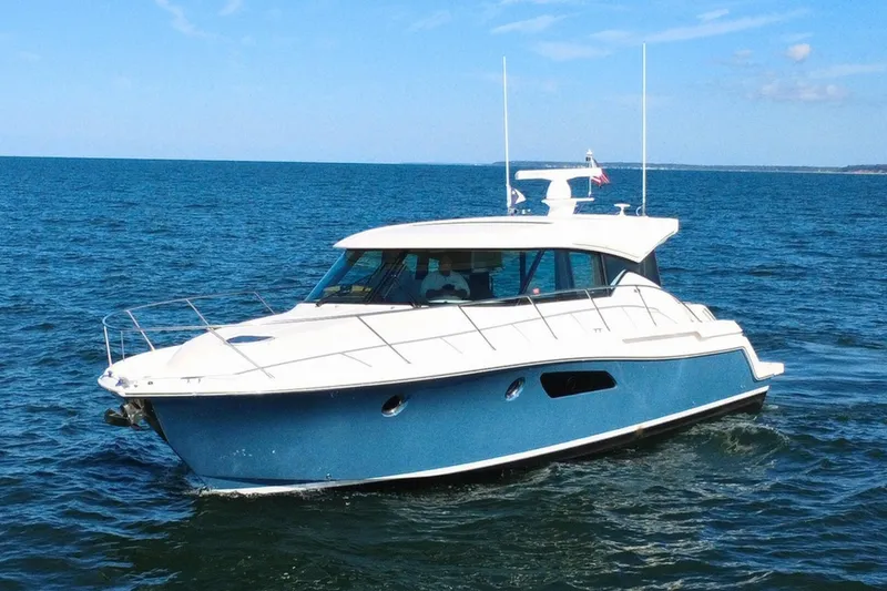 Slide: The Image of 2018 Tiara Yachts C44 Coupe cruising on open water under a clear blue sky. - 6