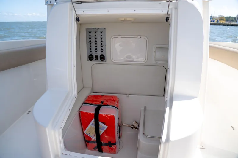 Slide: The Image of 2007 Chris-Craft Catalina 23 boat storage compartment with red emergency kit. - 13
