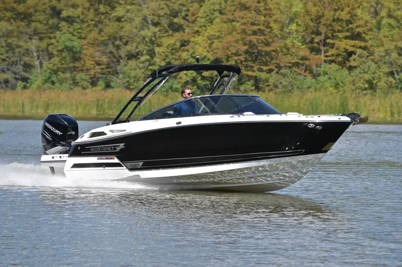 Slide: The Image of 2023 Monterey 275SS Super Sport boat cruising on a lake with lush green background. - 1