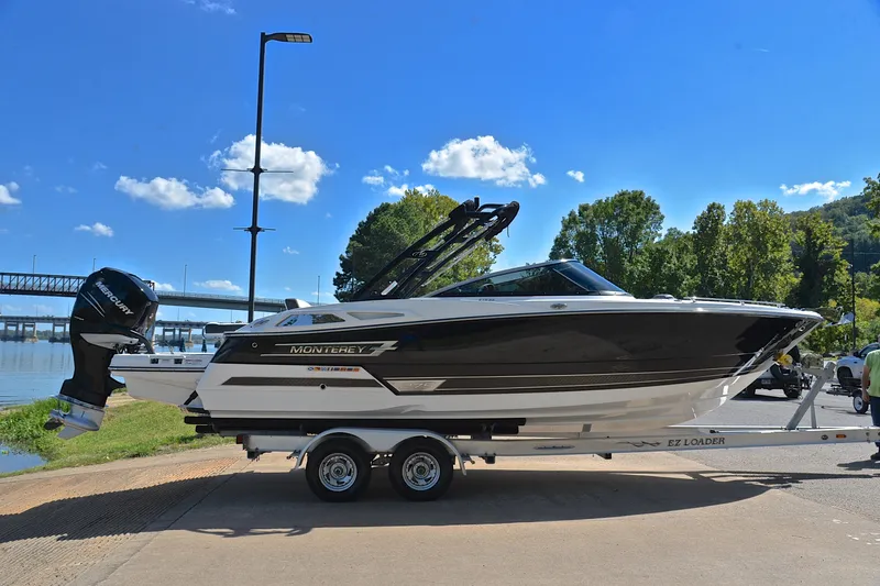 Slide: The Image of 2023 Monterey 275SS Super Sport boat on trailer by riverside, under clear blue sky. - 15