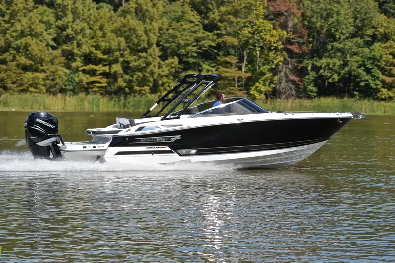 Slide: The Image of 2023 Monterey 275SS Super Sport boat cruising on a lake with lush green trees. - 3