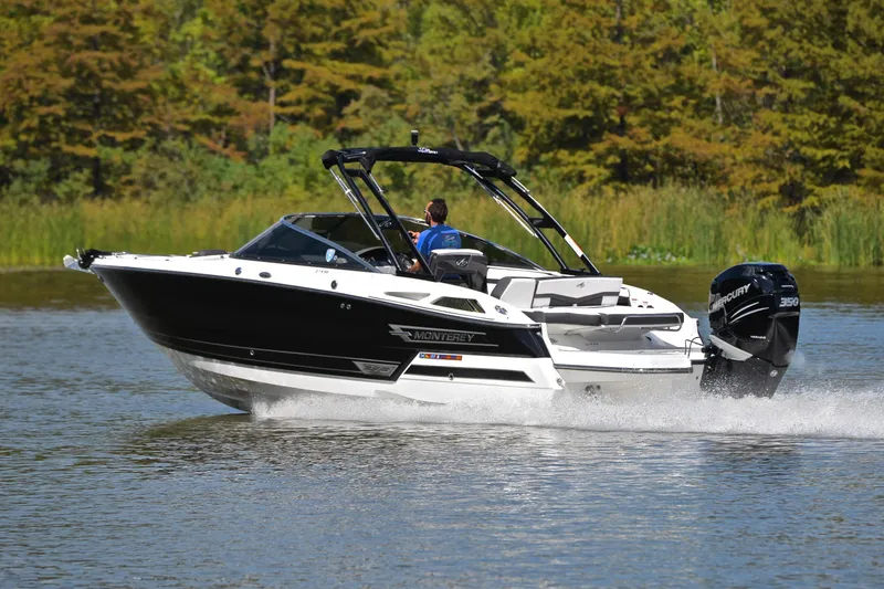Slide: The Image of 2023 Monterey 275SS Super Sport boat cruising on a lake with lush greenery. - 4