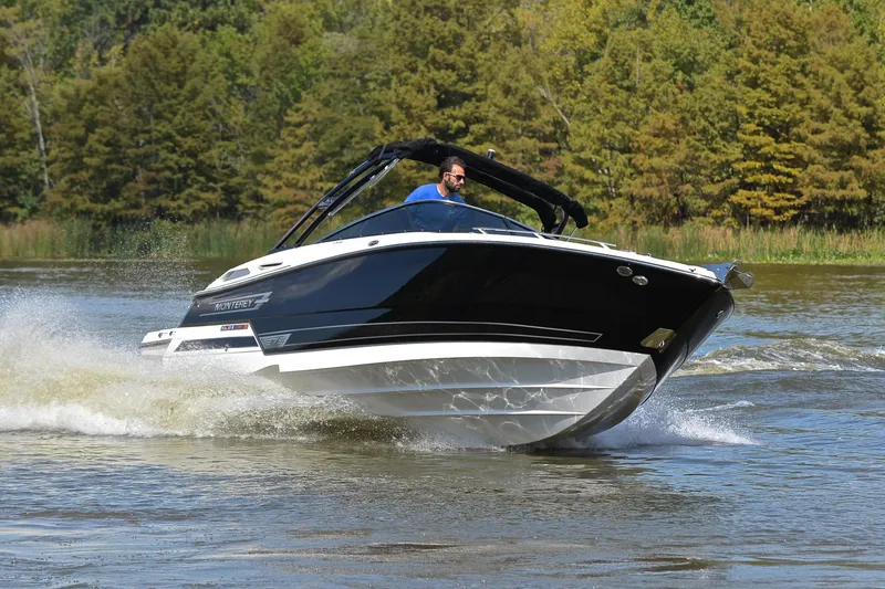 Slide: The Image of 2023 Monterey 275SS Super Sport boat cruising on a lake with lush green background. - 7