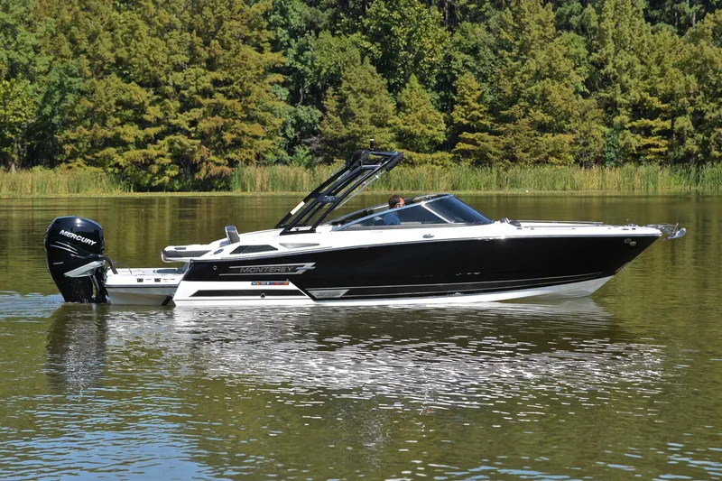 Slide: The Image of 2023 Monterey 275SS Super Sport boat on a serene lake with lush greenery. - 8