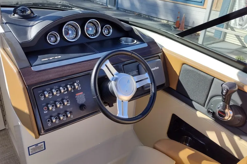 Slide: The Image of 2014 Sea Ray 270 SLX boat dashboard with steering wheel and control panel. - 10
