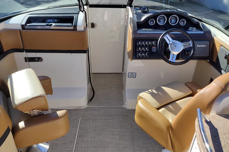 Slide: The Image of 2014 Sea Ray 270 SLX boat interior with tan seating and modern dashboard controls. - 17
