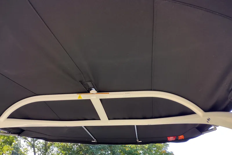 Slide: The Image of 2014 Sea Ray 270 SLX boat canopy, black fabric with metal frame, outdoor setting. - 38